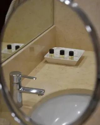 a mirror reflection of a bathroom sink with toiletries at Hotel Catedral in Funchal