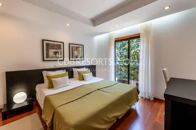 a bedroom with a large bed with a window at Baia da Luz Resort in Luz