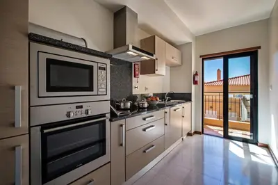 a kitchen with a stove and a microwave at Baia da Luz Resort in Luz