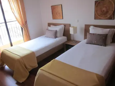 a bedroom with two beds and a window at Baia da Luz Resort in Luz