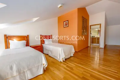 two beds in a bedroom with wood floors at Estrela da Luz Resort in Luz