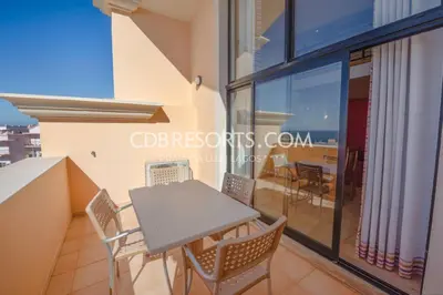 a room with a table and chairs on a balcony at Estrela da Luz Resort in Luz