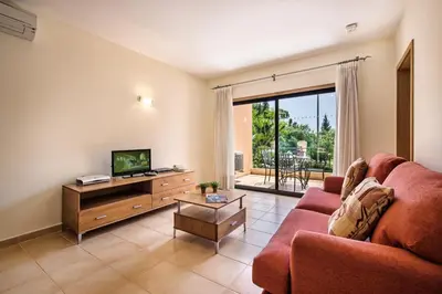 a living room with a couch and a tv at Estrela da Luz Resort in Luz
