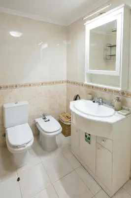 a white bathroom with a toilet and a sink at Apartment Ocean Gardens in Caniço