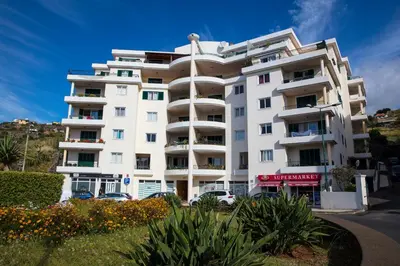 a white building with cars parked in front of it at Apartment Ocean Gardens in Caniço