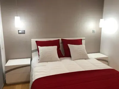 a bedroom with a bed with red and white pillows at Astro Vista Madeira Apartments in Funchal