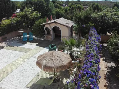 a garden with a small hut and flowers at Nature Beach Resort Quinta Al-Gharb in Vila do Bispo