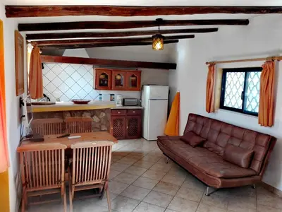 a living room with a couch and a kitchen at Nature Beach Resort Quinta Al-Gharb in Vila do Bispo