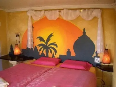 a bedroom with a large bed with pink pillows at Nature Beach Resort Quinta Al-Gharb in Vila do Bispo