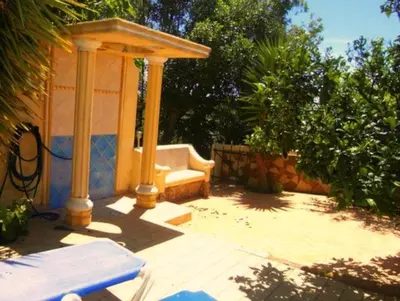 a gazebo with a bench on a patio at Nature Beach Resort Quinta Al-Gharb in Vila do Bispo