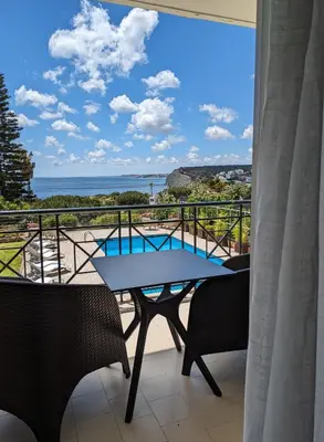 a balcony with a table and chairs and a view of the ocean at Vivenda Solmar in Lagos