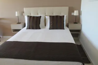 a bedroom with a large white bed with two night stands at Vivenda Solmar in Lagos