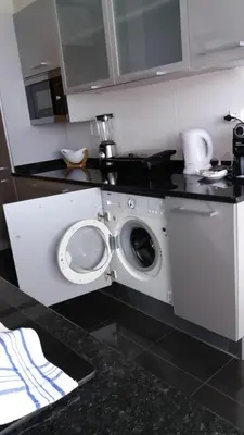 a kitchen with a washing machine under a counter at Lou-Jos in Funchal