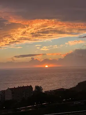 a sunset with the ocean in the background at Madeira Mar - 