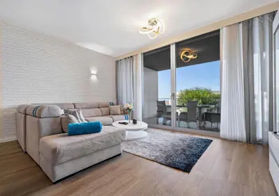 a living room with a couch and a large window at Madeira Mar - 