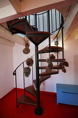 a spiral staircase in a room with hanging balls at Casa Benedita in Ponta do Pargo