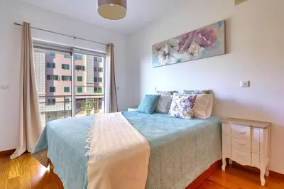 a bedroom with a bed and a large window at Blue Sky Apartment with pool by Holiday Rental Madeira in Funchal