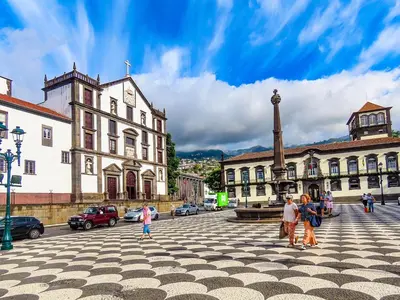 a group of people walking in a plaza in front of a building at Blue Sky Apartment with pool by Holiday Rental Madeira in Funchal