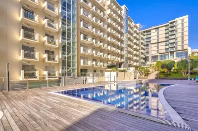 a building with a swimming pool in front of a building at Blue Sky Apartment with pool by Holiday Rental Madeira in Funchal
