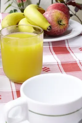 a glass of orange juice next to a plate of fruit at Hotel GORDON in Funchal
