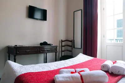 a bedroom with a bed with towels and a dresser at Hotel GORDON in Funchal