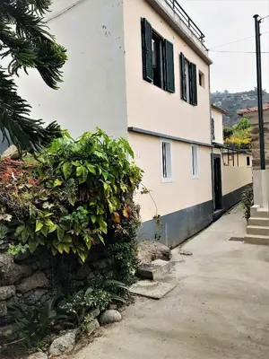 a living room with a white couch and a television at Casa do Figueirinha in Campanário