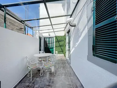 a white building with green shutters on it at Casa do Figueirinha in Campanário