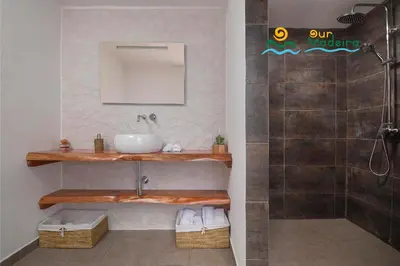 a bathroom with a sink and a shower at OurMadeira - Casa da Rosalina in Calheta
