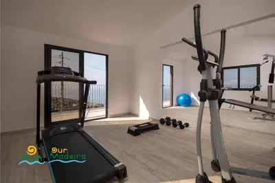 a fitness room with a treadmill and a gym at OurMadeira - Casa da Rosalina in Calheta