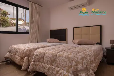 a bedroom with two beds and a sign on the wall at OurMadeira - Casa da Rosalina in Calheta