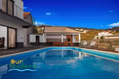 a swimming pool in front of a house at OurMadeira - Casa da Rosalina in Calheta