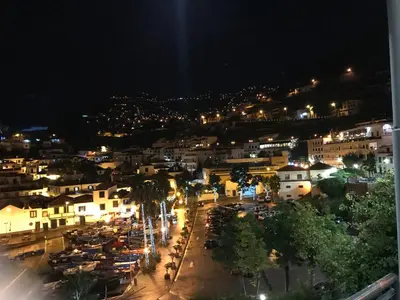 a city at night with cars parked in a parking lot at Estúdio Laura in Câmara de Lobos