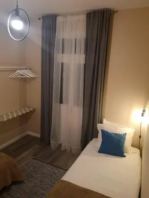 a bed with a blue pillow in front of a window at Apartment Madeira Happiness in Funchal