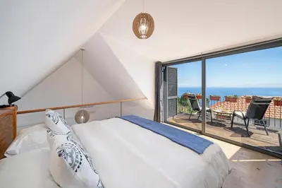 a bedroom with a bed and a view of the ocean at OurMadeira - Quinta Inácia in Calheta
