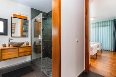 a bathroom with a shower with a glass door at Valley View-Villa with heated pool and sauna in Arco da Calheta