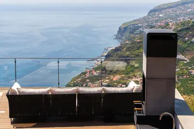 a balcony with a view of the ocean at Valley View-Villa with heated pool and sauna in Arco da Calheta