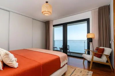 a bedroom with a bed and a view of the ocean at Valley View-Villa with heated pool and sauna in Arco da Calheta