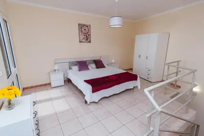 a bedroom with a bed and a staircase in it at Calheta Holiday Houses in Arco da Calheta