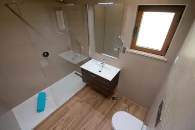 a bathroom with a sink and a shower and a toilet at Casa da Ladeira Branca in Lagos