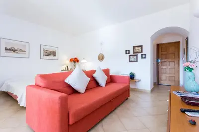 a living room with a red couch and a bed at Magnoliamar 409 in Lagos