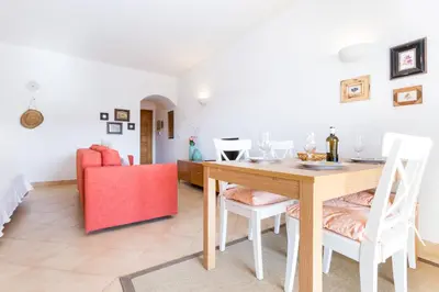 a dining room with a table and a red couch at Magnoliamar 409 in Lagos