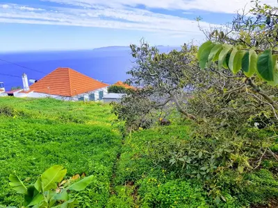an orange roofed house on a green hill with the ocean at Paradise View in Gaula