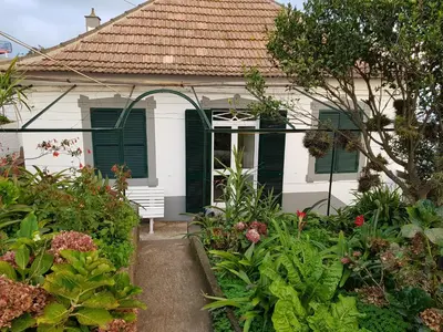 a white house with green shutters and a garden at Paradise View in Gaula