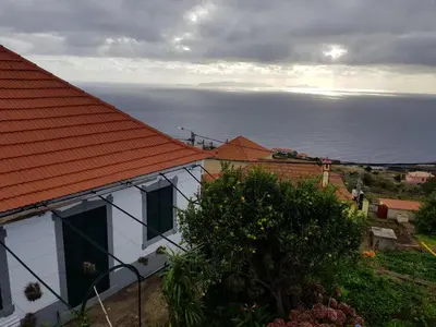 a white house with an orange roof and the ocean at Paradise View in Gaula
