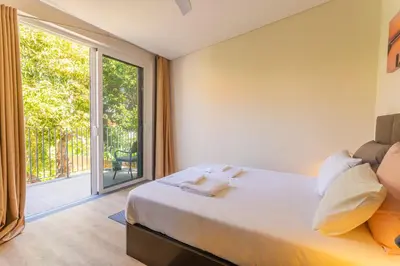 a bedroom with a bed and a large window at FLH Quintinha Rocha in Funchal