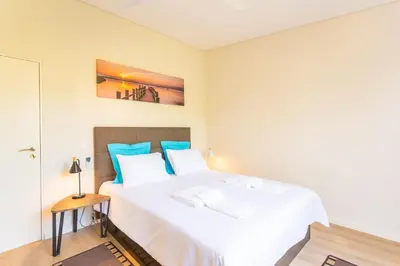 a bedroom with a large white bed with blue pillows at FLH Quintinha Rocha in Funchal