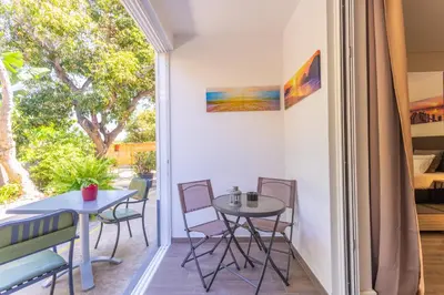 a room with a balcony with a table and chairs at FLH Quintinha Rocha in Funchal