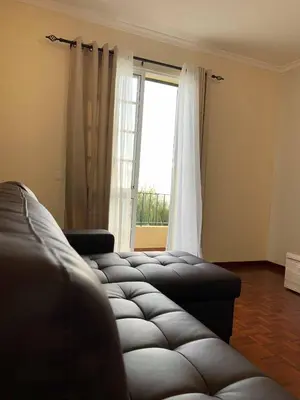 a living room with a couch and a window at Ilha Atlântico in Caniço