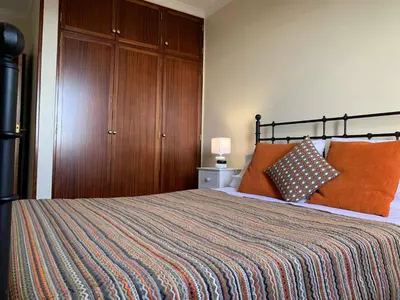 a bedroom with a large bed with orange pillows at Ilha Atlântico in Caniço