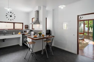 a kitchen with a sink and a counter with stools at Casa do Lido by An Island Apart in Funchal